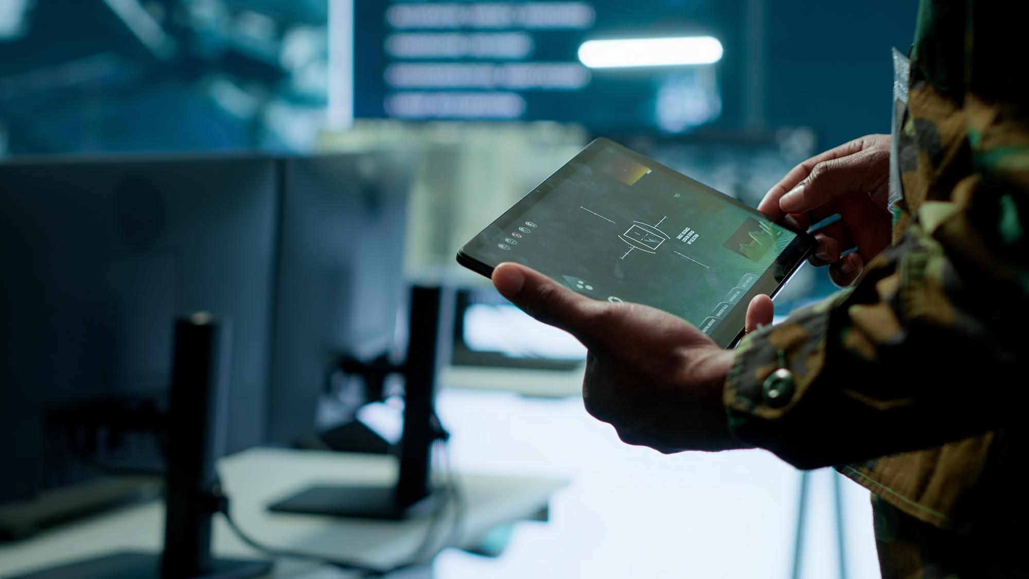 軍事人員使用平板電腦查看戰術系統介面
