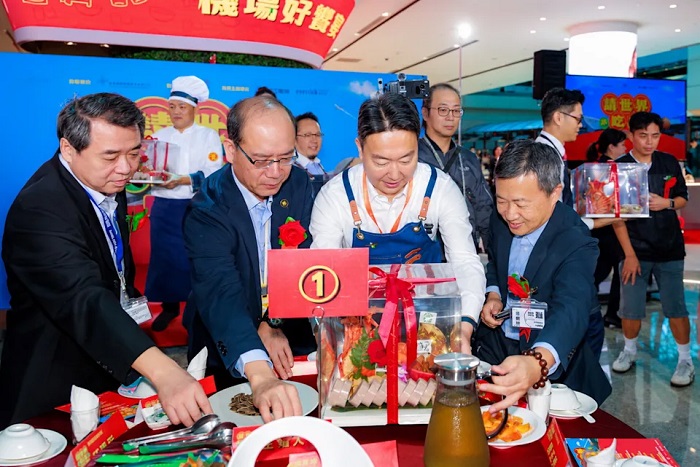 讓傳統辦桌文化在國門展開全新餐飲體驗,交通部長陳世凱換上圍裙親自上菜。(昇恆昌免稅商店提供)